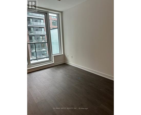 A room with a large window and a view of a building across the street.