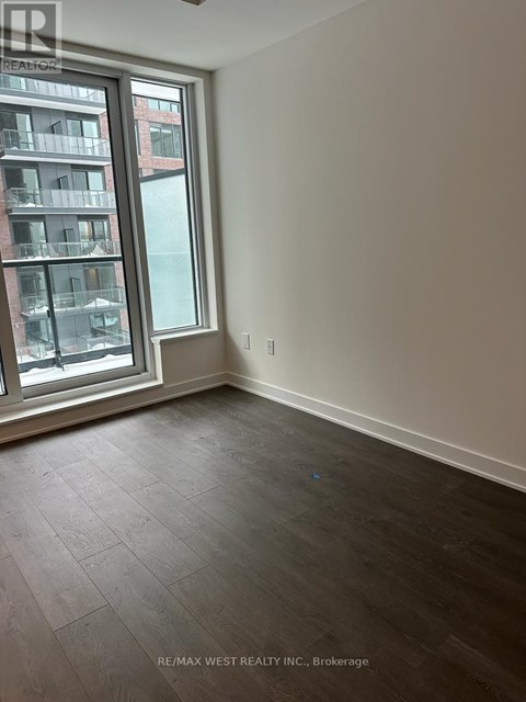 A room with a large window and a view of a building across the street.