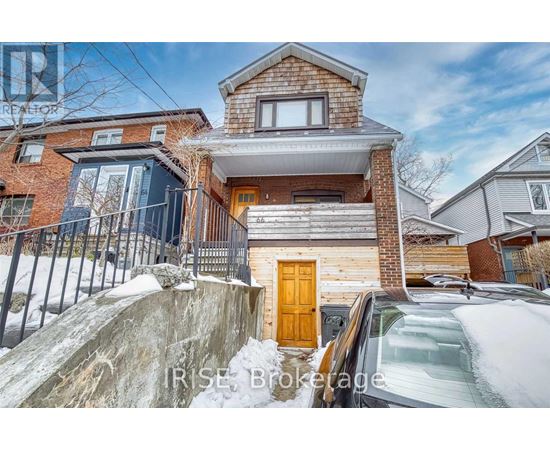 A house with a brown door is surrounded by snow.