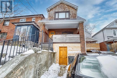 A house with a brown door is surrounded by snow.