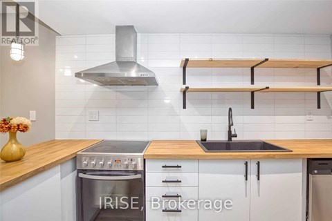 A modern kitchen with a stove top oven and a double sink.