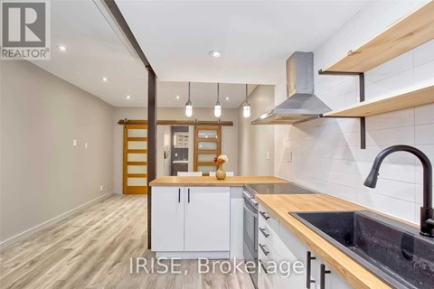 A modern kitchen with white cabinets and a wooden countertop.