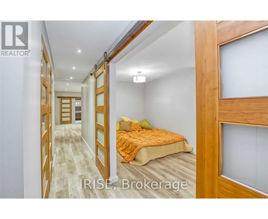 A bedroom with a bed and a window with a view of the hallway.