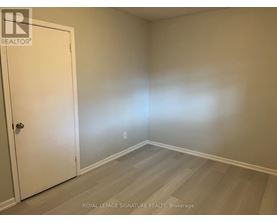 A room with a white door and wooden flooring.