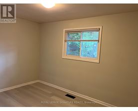 A room with a window showing trees outside.