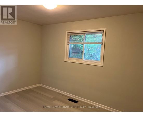A room with a window showing trees outside.