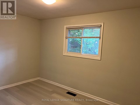 A room with a window showing trees outside.