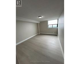 A room with a window and wooden flooring.