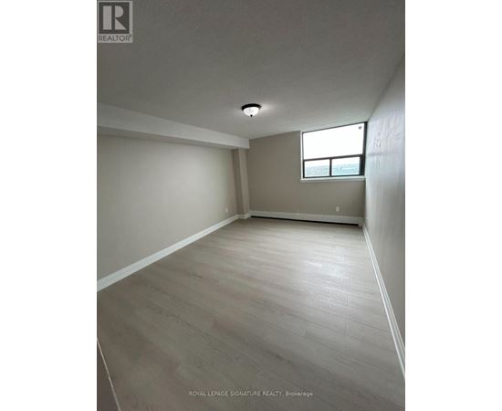 A room with a window and wooden flooring.