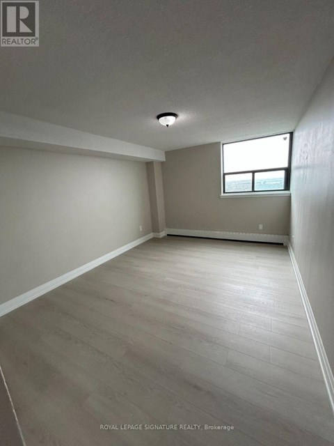 A room with a window and wooden flooring.