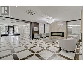 A spacious living room with a fireplace and a chandelier.