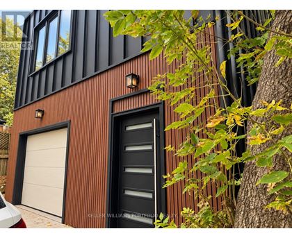 A modern house with a black door and a white garage door.