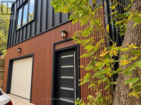A modern house with a black door and a white garage door.