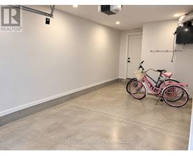 A pink bicycle is parked in a spacious, empty room.