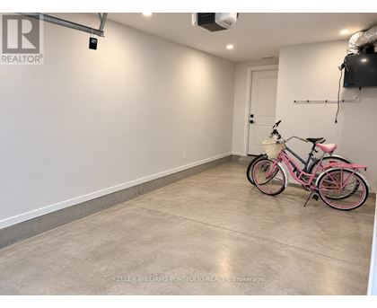 A pink bicycle is parked in a spacious, empty room.