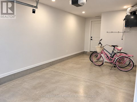 A pink bicycle is parked in a spacious, empty room.