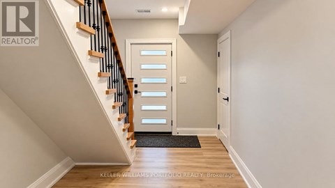 A hallway with a staircase and a door.