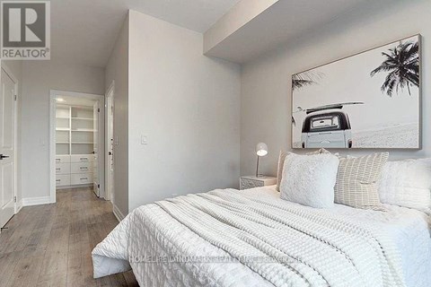 A bedroom with a large bed and a painting of a van on the wall.