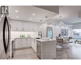 A modern kitchen with white cabinets and a marble island.