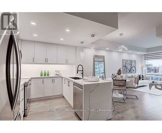 A modern kitchen with white cabinets and a marble island.