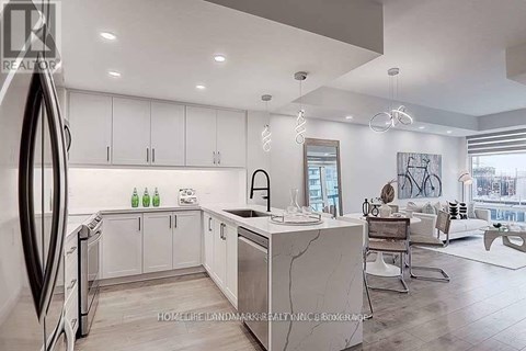A modern kitchen with white cabinets and a marble island.
