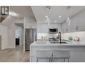 A modern kitchen with white cabinets and a stainless steel refrigerator.