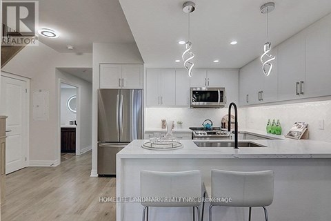A modern kitchen with white cabinets and a stainless steel refrigerator.