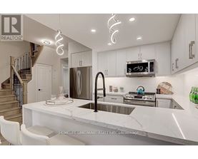 A modern kitchen with a marble countertop and stainless steel appliances.