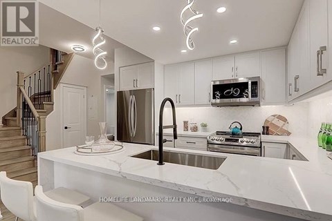 A modern kitchen with a marble countertop and stainless steel appliances.