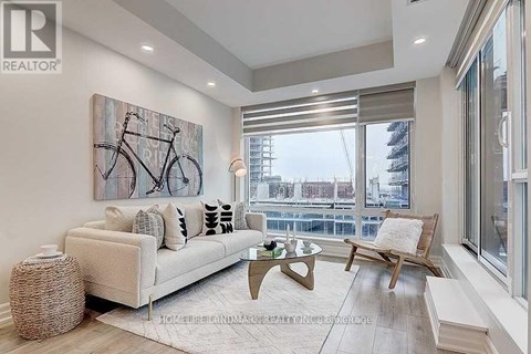 A living room with a large painting of a bicycle on the wall.