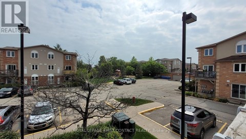 A parking lot with cars and apartment buildings in the background.