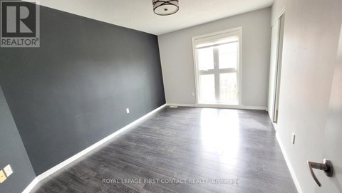 A room with a grey wall and a window letting in sunlight.