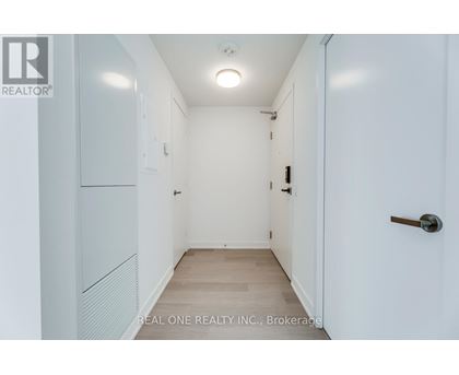 A white hallway with a door on the right.