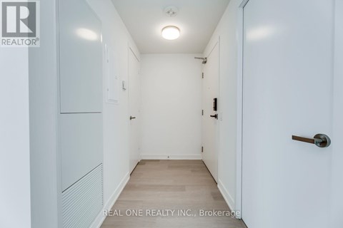 A white hallway with a door on the right.