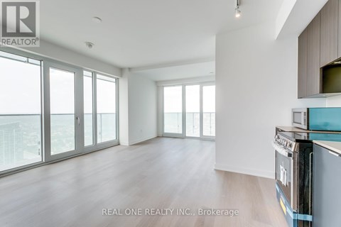 A spacious, empty room with a view of the city through large windows.