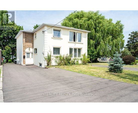 A white two-story house with a driveway in front.