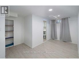 A white room with a grey curtain and a sign that says Intercity Realty Inc. Brokerage.