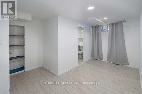 A white room with a grey curtain and a sign that says Intercity Realty Inc. Brokerage.