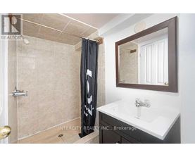 A bathroom with a shower, sink, and mirror.