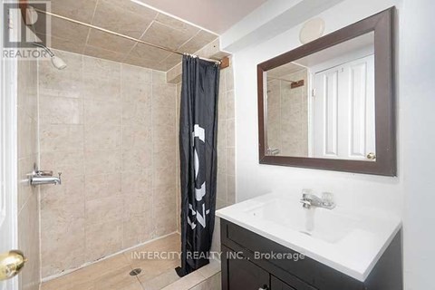 A bathroom with a shower, sink, and mirror.