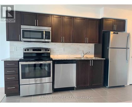 A kitchen with brown cabinets and a white refrigerator.