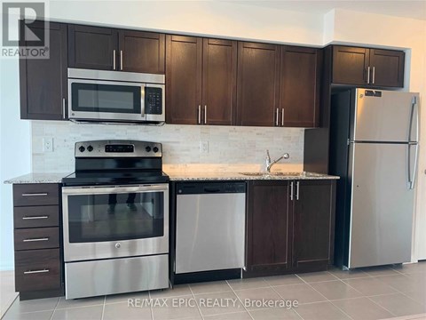 A kitchen with brown cabinets and a white refrigerator.