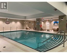A large indoor swimming pool with a RE/MAX Epic Realty logo on the wall.