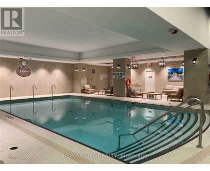 A large indoor swimming pool with a RE/MAX Epic Realty logo on the wall.