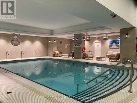 A large indoor swimming pool with a RE/MAX Epic Realty logo on the wall.
