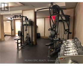 A gym with a variety of equipment including a treadmill, a stationary bike, and a rowing machine.