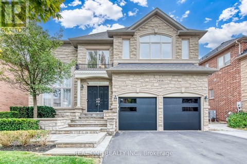 A two-story house with a stone facade and a black garage door.