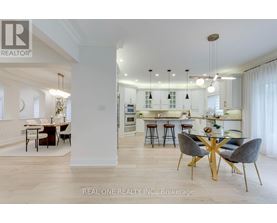 A modern kitchen with a dining table set up with four chairs.