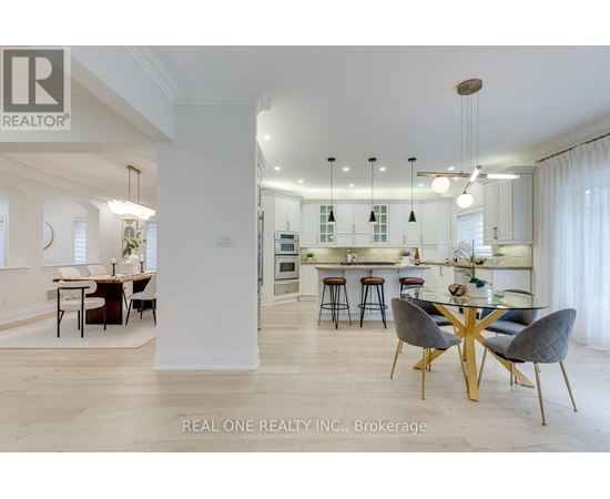 A modern kitchen with a dining table set up with four chairs.