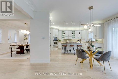A modern kitchen with a dining table set up with four chairs.